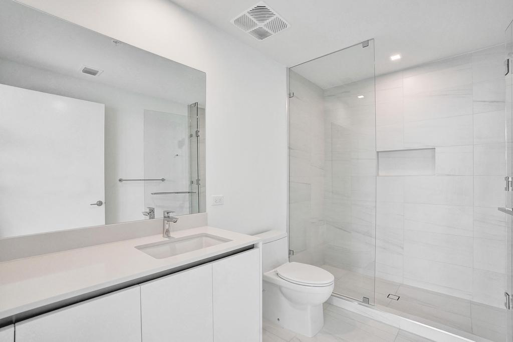 900 North Ocean Boulevard, Unit 1405 Pompano Beach, FL 33062 - Photo 34 of 67 a bathroom with a sink a toilet and shower