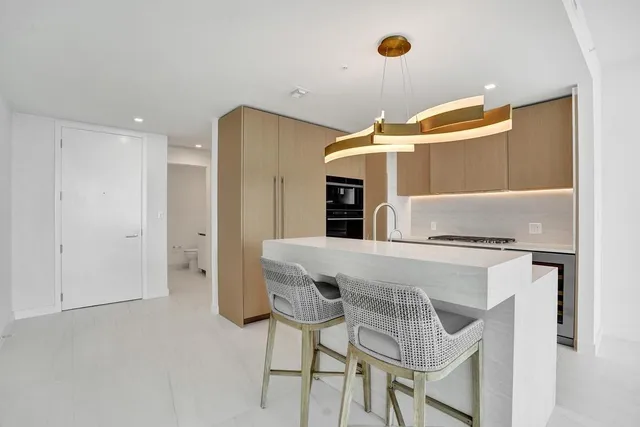 a kitchen with stainless steel appliances granite countertop a sink a stove and a refrigerator