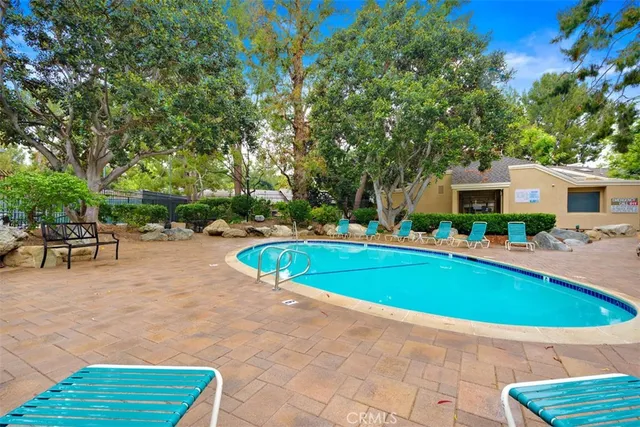 a view of a patio with table and chairs potted plants and large tree