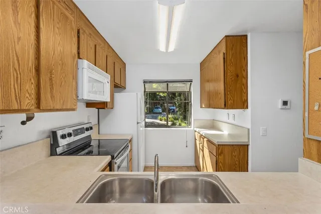 a kitchen with a sink a counter top space and cabinets