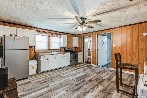 a kitchen with a refrigerator a stove cabinets projector and a dining table