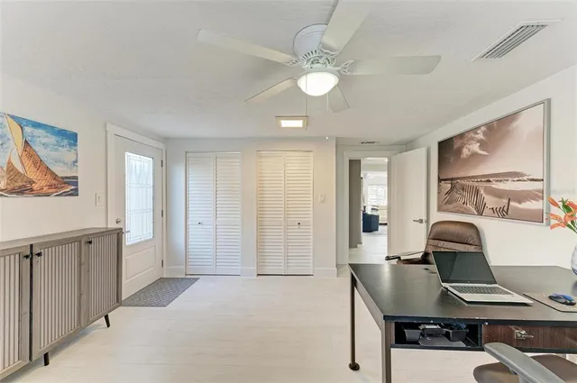 a view of a workspace with furniture and a window