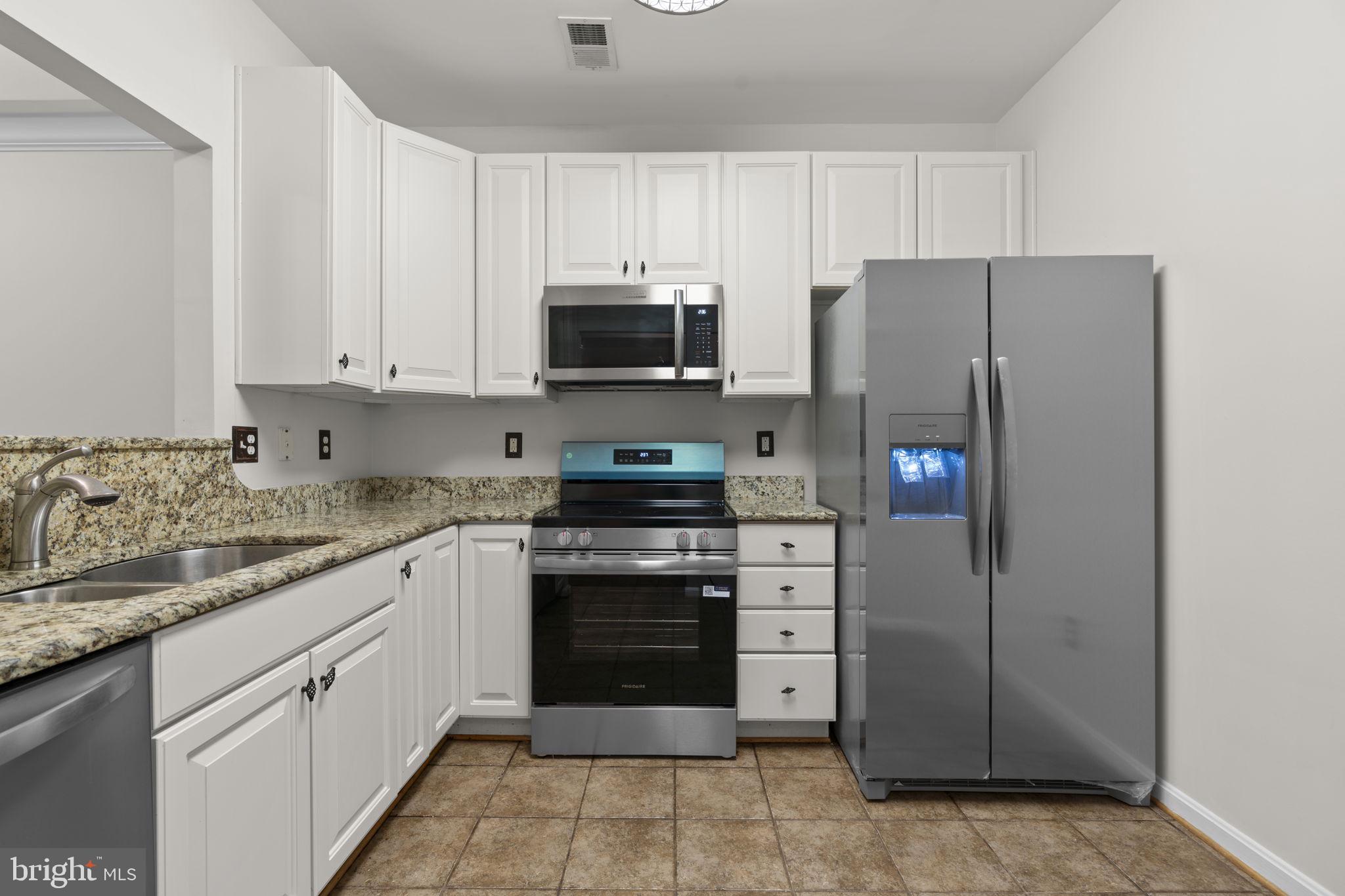 7315 Maplecrest Road, Unit 104 Elkridge, MD 21075 - Photo 18 of 58 a kitchen with stainless steel appliances granite countertop a refrigerator stove and sink