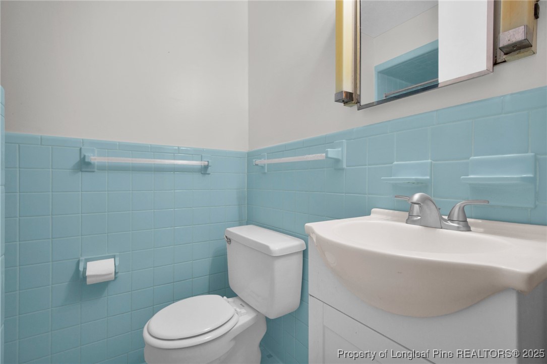 215 South 7th Street Spring Lake, NC 28390 - Photo 20 of 37 a bathroom with a sink a toilet and a mirror