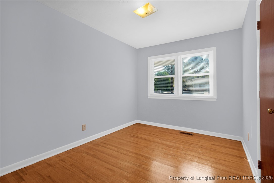 215 South 7th Street Spring Lake, NC 28390 - Photo 22 of 37 a view of an empty room with wooden floor and a window