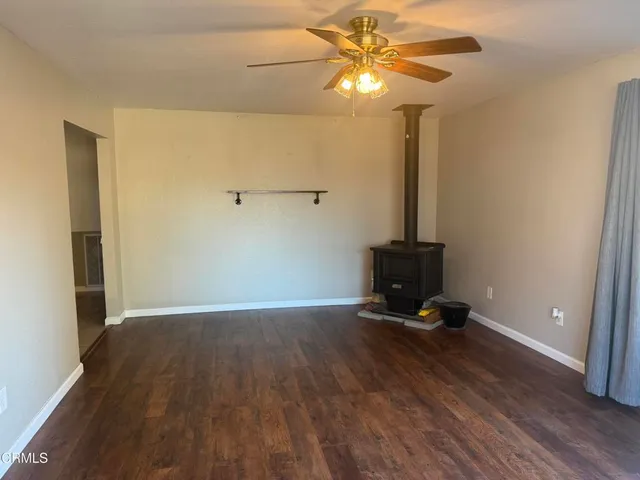 a view of room with a ceiling fan and wooden floor