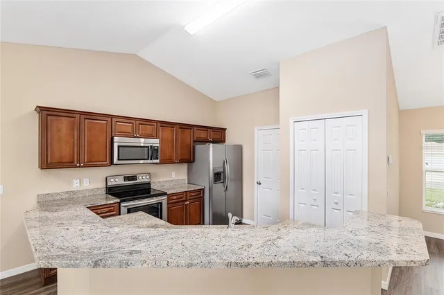 a kitchen with stainless steel appliances granite countertop a sink refrigerator and microwave