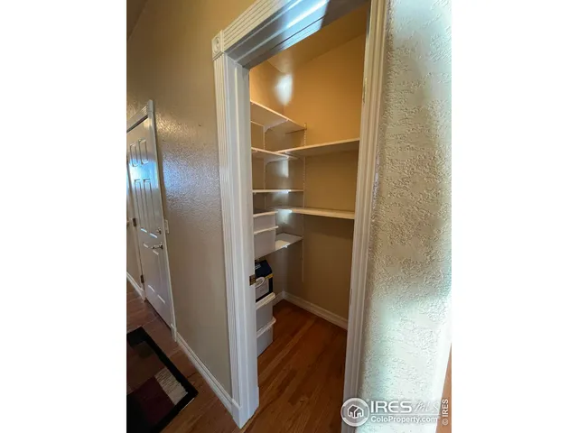 a view of a hallway with wooden floor and entryway