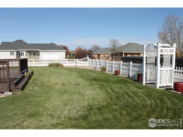 a view of a big house with a big yard and large trees