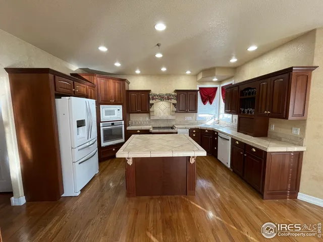 a large kitchen with stainless steel appliances wooden floors and wooden cabinets