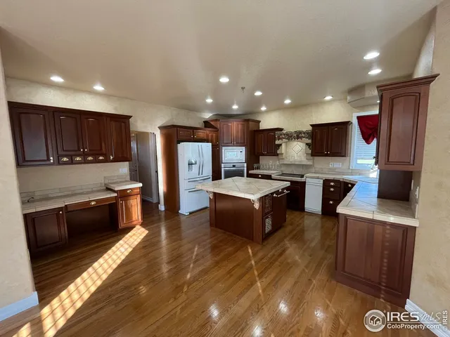 a large kitchen with stainless steel appliances wooden cabinets and a stove top oven