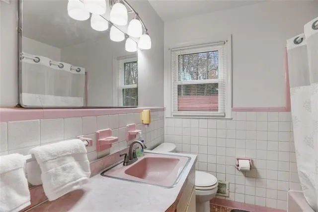 a bathroom with a toilet sink and mirror