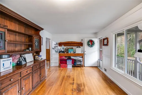 a utility room with stainless steel appliances wooden floor and a window