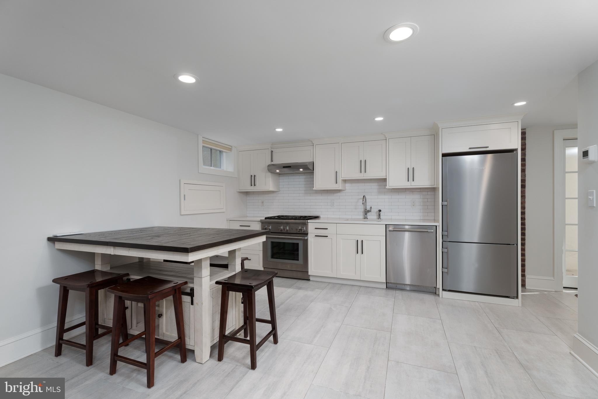 109 Moore Street Princeton, NJ 08540 - Photo 6 of 26 a kitchen with stainless steel appliances a stove a sink refrigerator and white cabinets with wooden floor