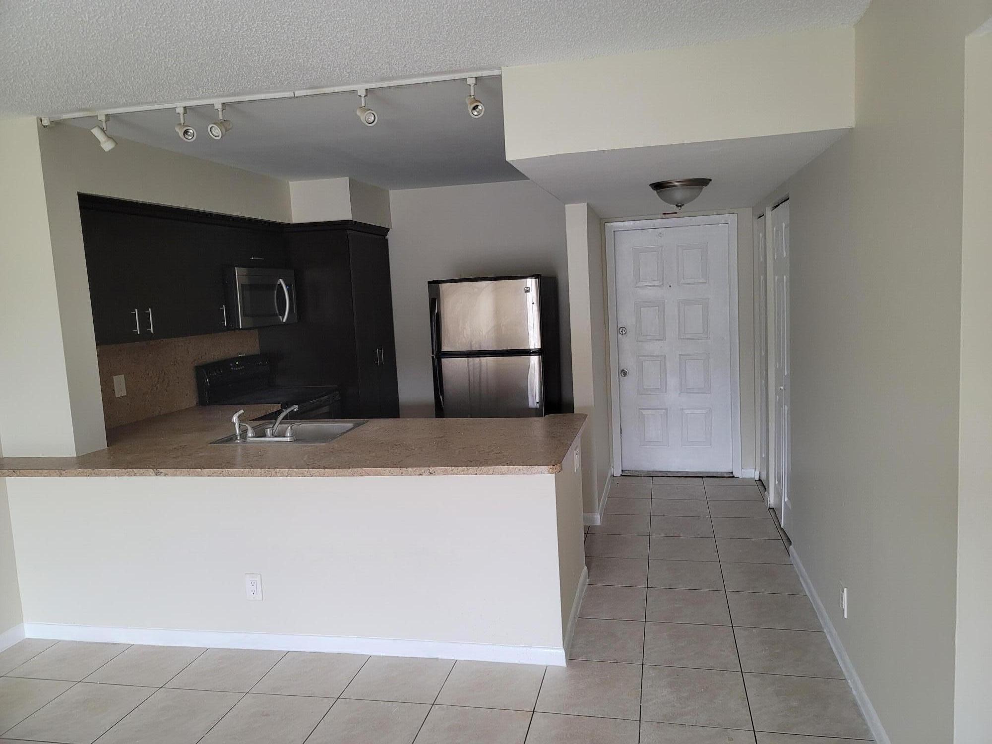 3700-3730 North Pine Island Road, Unit 249 Sunrise, FL 33351 - Photo 2 of 18 a kitchen with a sink and a refrigerator
