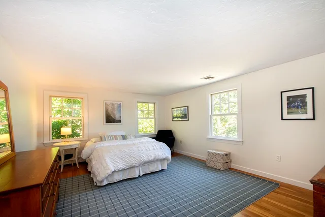 a bedroom with a bed wooden floor and a window