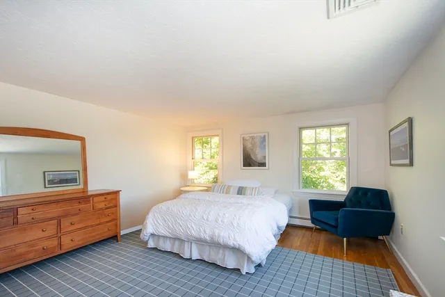 a bedroom with a bed wooden floor and window