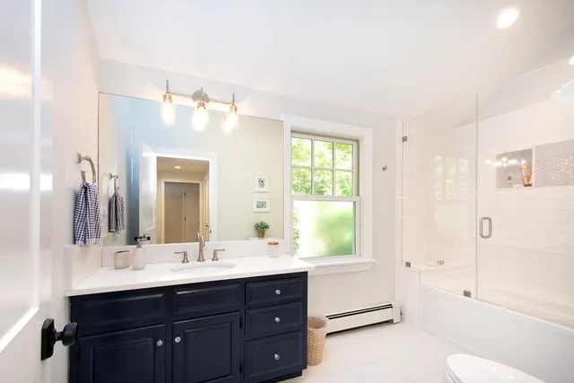 a bathroom with a tub sink toilet and mirror