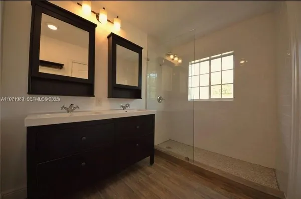 a bathroom with double vanity sink and mirror