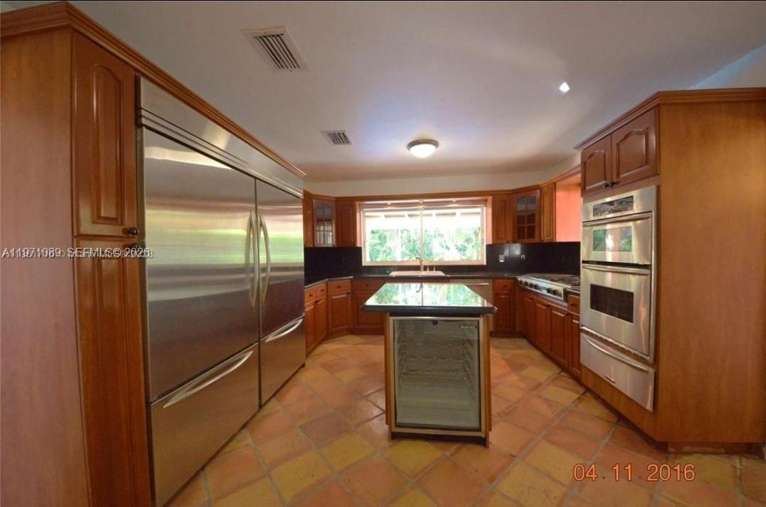 510 Bird Road Coral Gables, FL 33146 - Photo 8 of 9 a kitchen with stainless steel appliances granite countertop a refrigerator and a stove