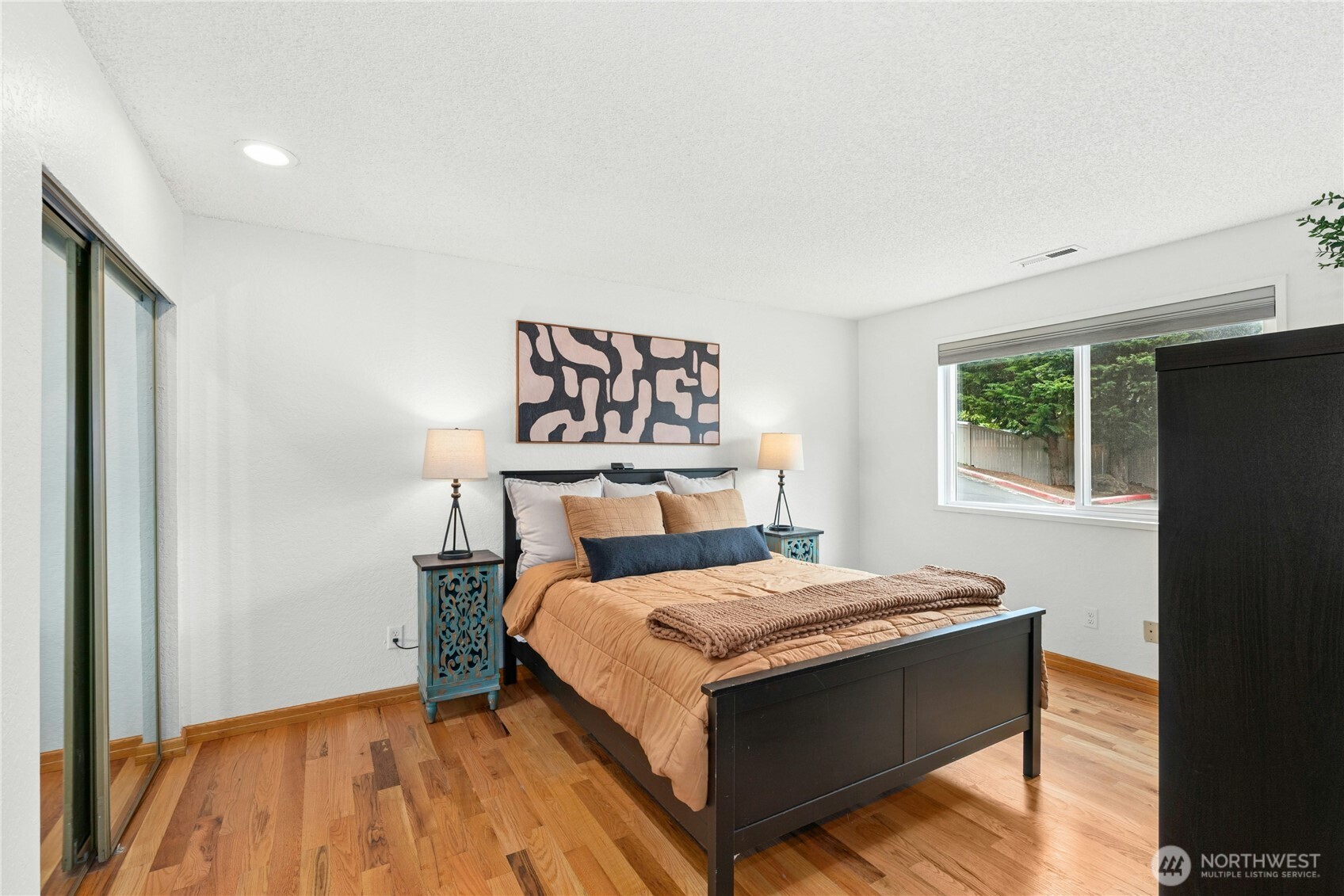 9523 Northeast 180th Street, Unit A102 Bothell, WA 98011 - Photo 14 of 29 a bed sitting in a bedroom next to a window