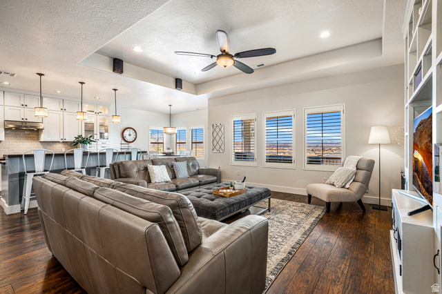 2311 South 1340 West St. George, UT 84770 - Photo 15 of 56 Living area featuring a tray ceiling, recessed lighting, a ceiling fan, dark wood-type flooring, and a textured ceiling