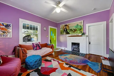 a living room with furniture a fireplace and a large window