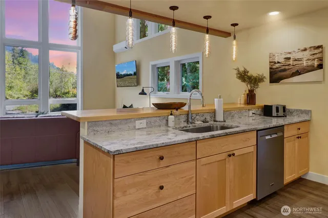 a kitchen with granite countertop a sink cabinets and wooden floor