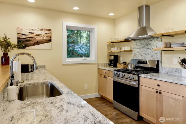 a kitchen with stainless steel appliances granite countertop a sink stove and refrigerator