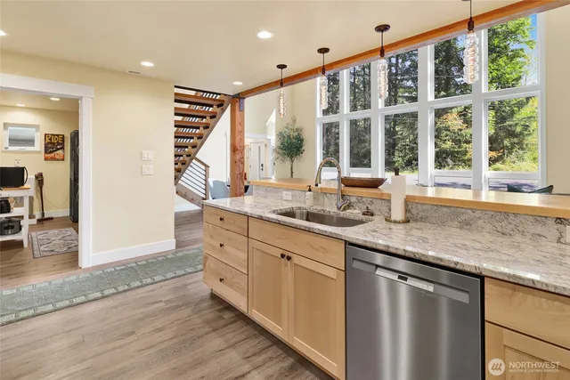 a open kitchen with granite countertop a sink and dishwasher with wooden floor