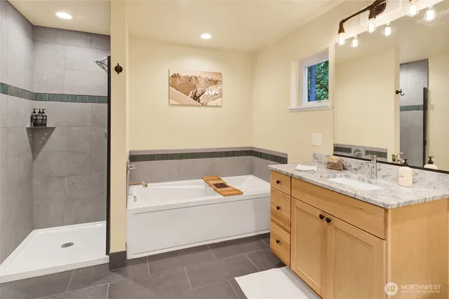 a bathroom with a tub sink and mirror