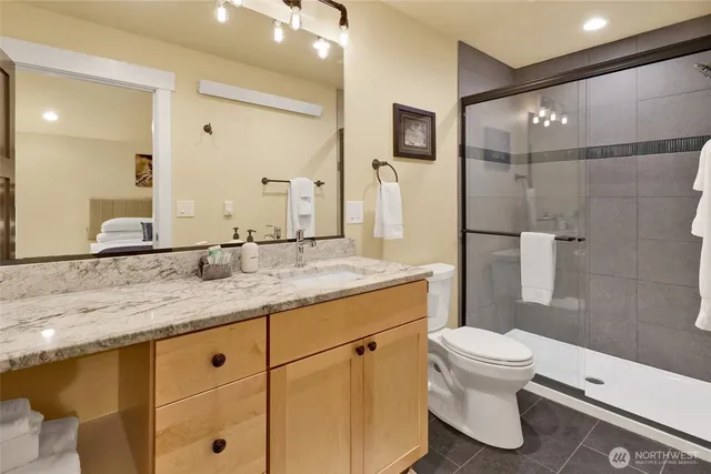 a bathroom with a granite countertop sink toilet and shower