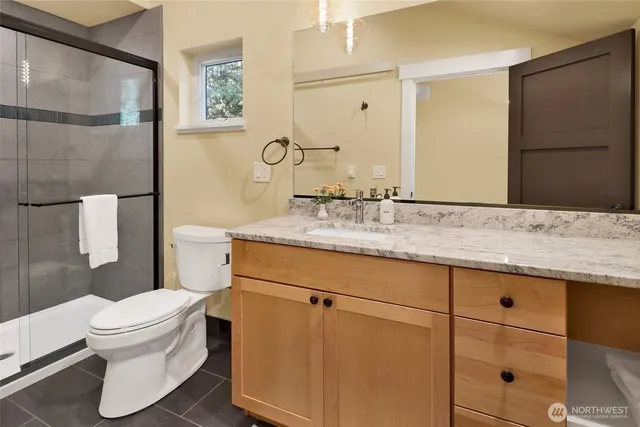 a bathroom with a granite countertop sink toilet and shower