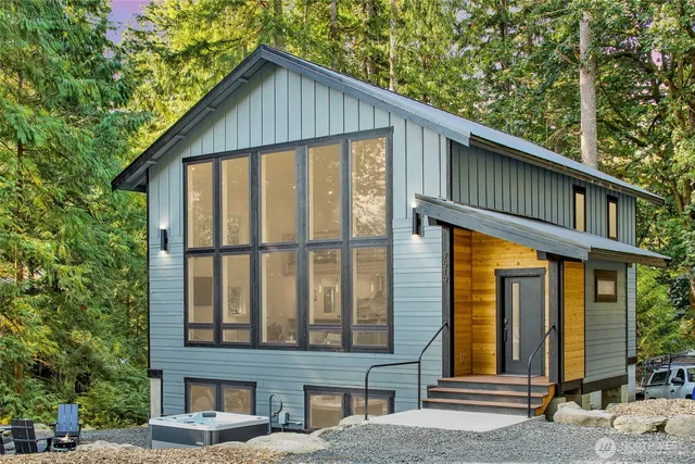 a view of a house with large windows and a small yard