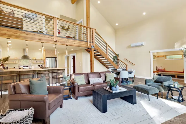 a living room with furniture wooden floor and a large window