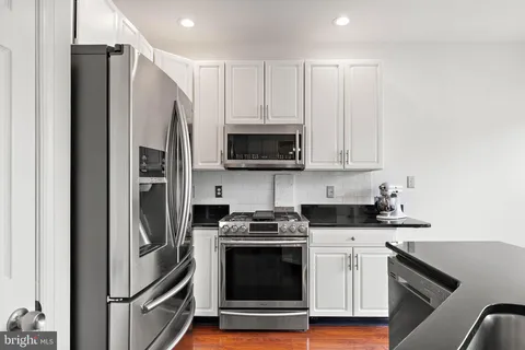 a kitchen with stainless steel appliances a stove a microwave and a refrigerator
