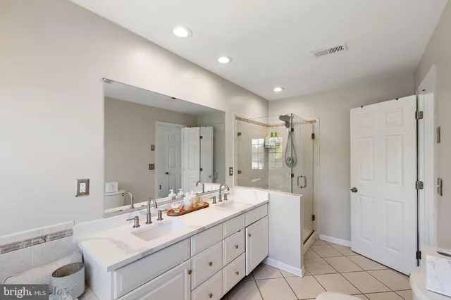 a spacious bathroom with a double vanity sink mirror and double