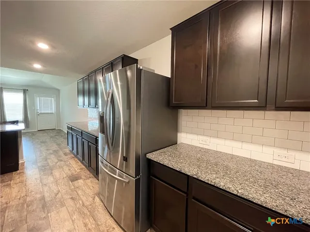 a kitchen with stainless steel appliances granite countertop a refrigerator and a sink