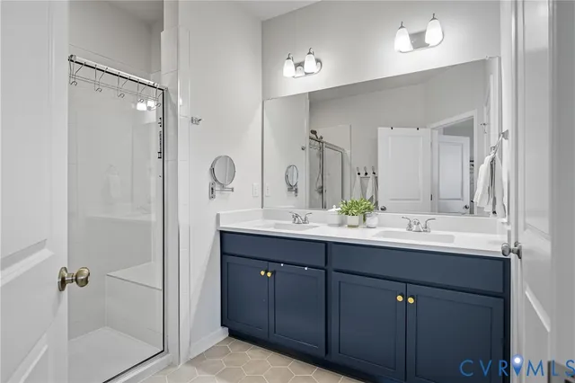 a bathroom with a double vanity sink mirror and shower