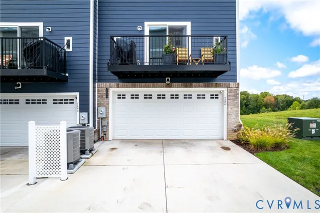 a view of a brick house with a yard and potted plants