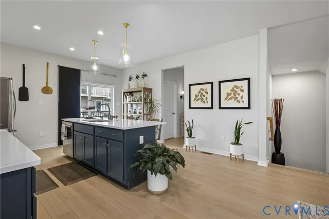 a kitchen with stainless steel appliances kitchen island granite countertop a refrigerator and a sink