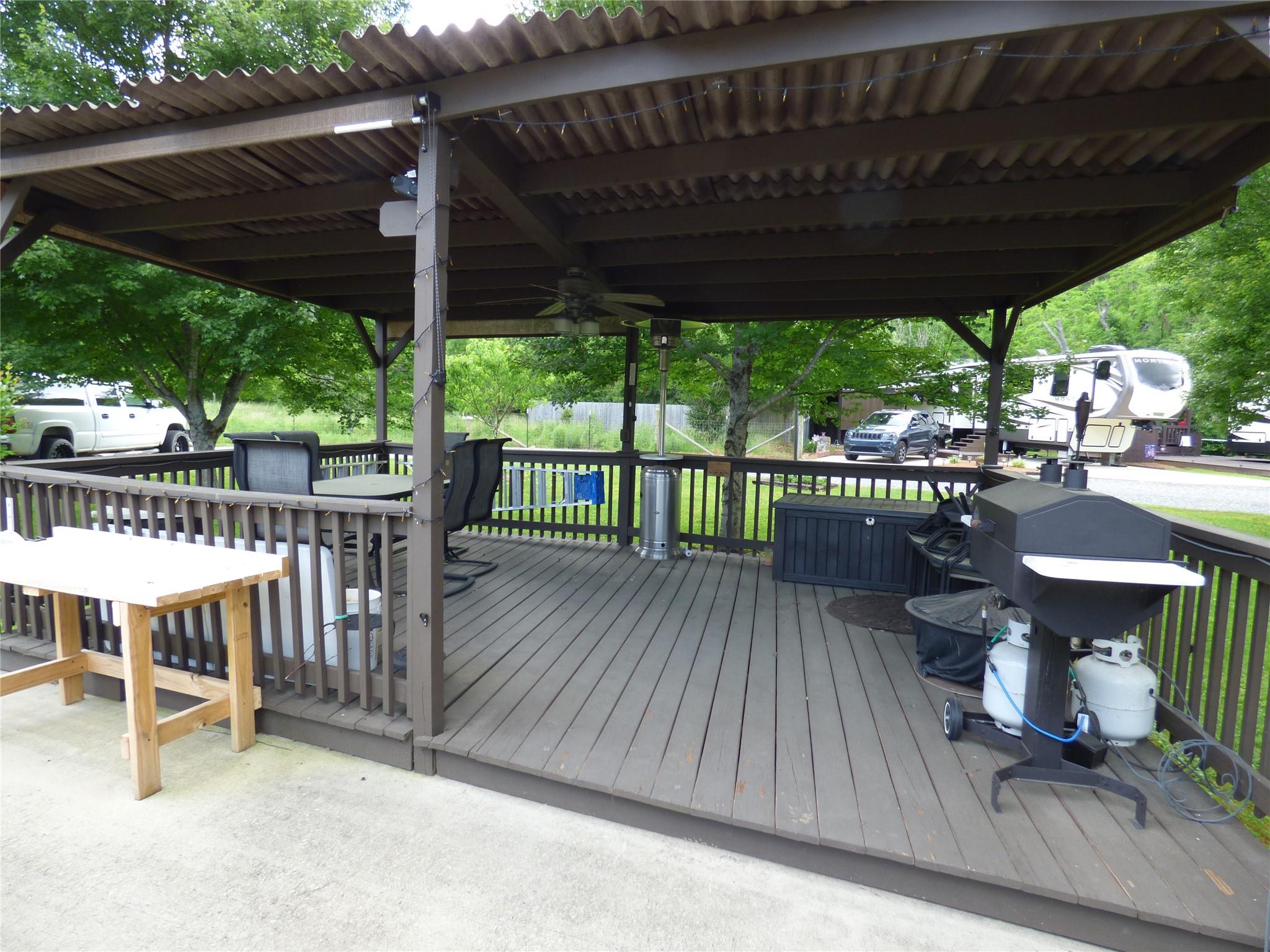 50 Timber Leaf Drive, Unit 12 Sylva, NC 28779 - Photo 11 of 14 a view of a roof deck with table and chairs under an umbrella with a wooden floor