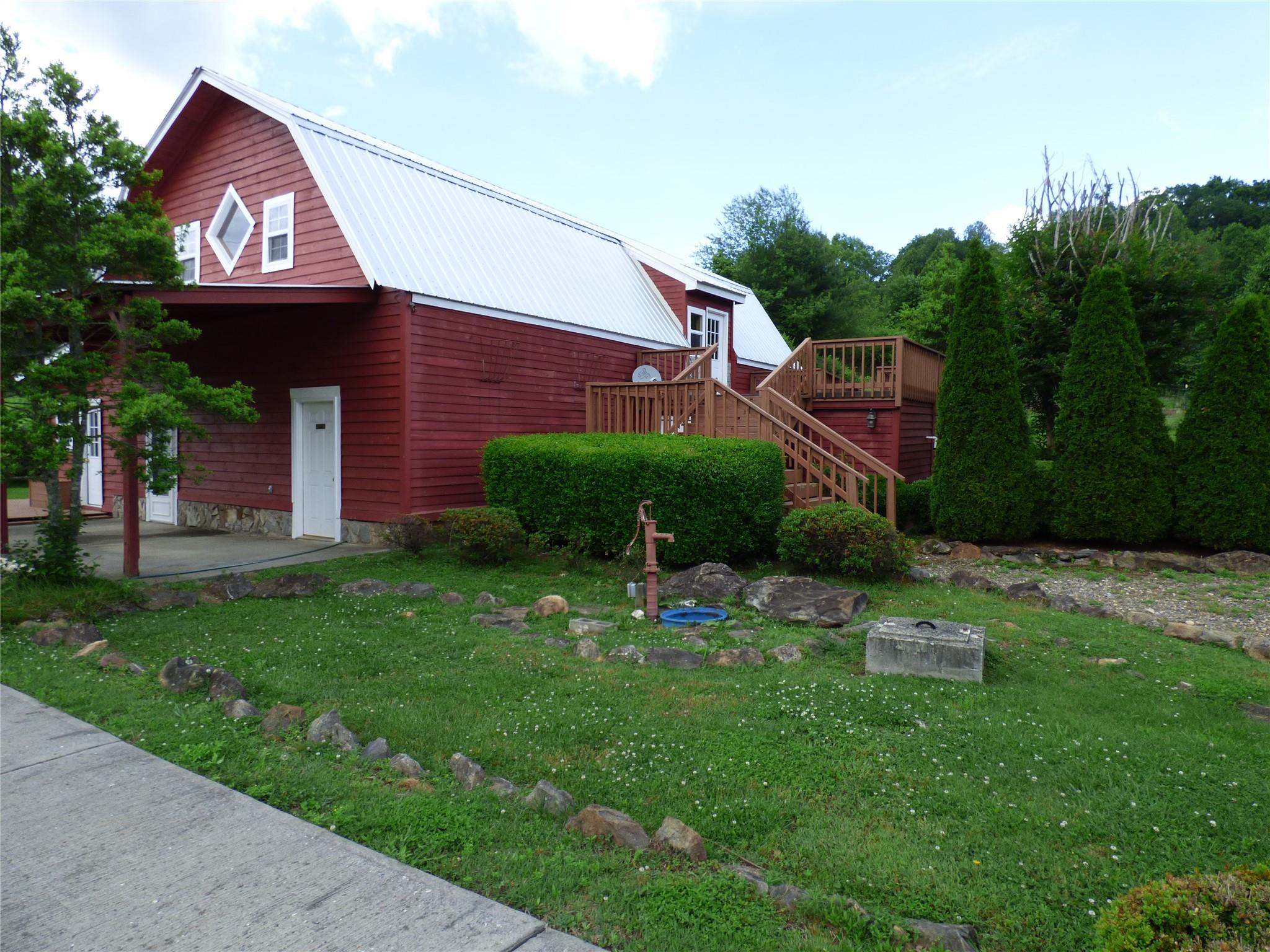 50 Timber Leaf Drive, Unit 12 Sylva, NC 28779 - Photo 5 of 14 a view of a brick house with a small yard and a large tree
