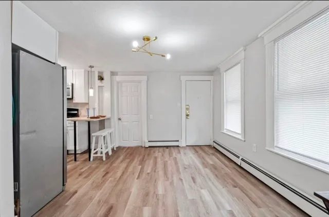 a view of a kitchen with wooden floor and a refrigerator