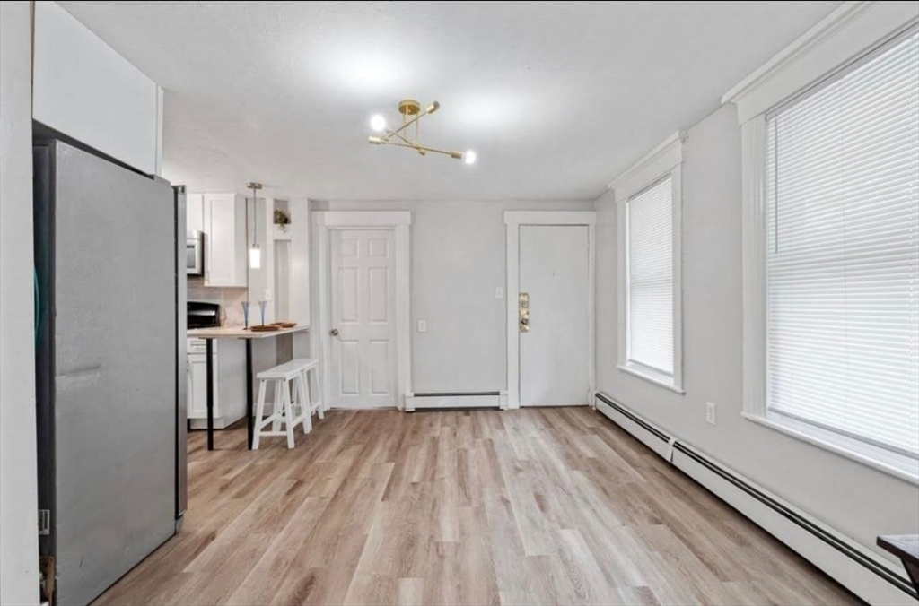 320 Cedar Street, Unit 2 Manchester, NH 03103 - Photo 2 of 5 a view of a kitchen with wooden floor and a refrigerator