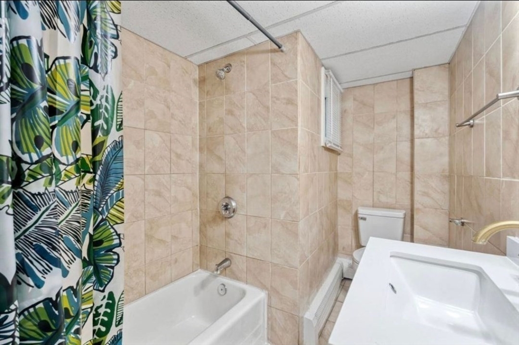 320 Cedar Street, Unit 2 Manchester, NH 03103 - Photo 3 of 5 a bathroom with a sink a bathtub and shower