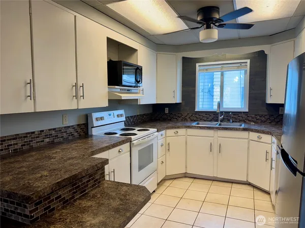 a kitchen with stainless steel appliances granite countertop a stove a sink and a microwave