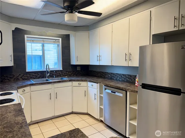 a kitchen with granite countertop a sink stainless steel appliances and cabinets