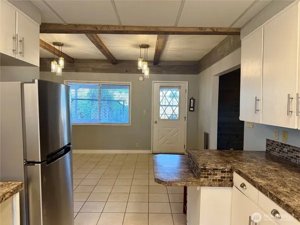 a kitchen with stainless steel appliances granite countertop a refrigerator a stove and a sink