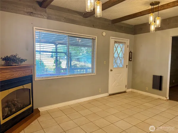 a view of an empty room with wooden floor and a fireplace